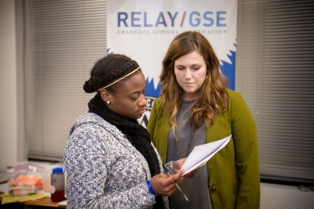 Two women discussing a paper